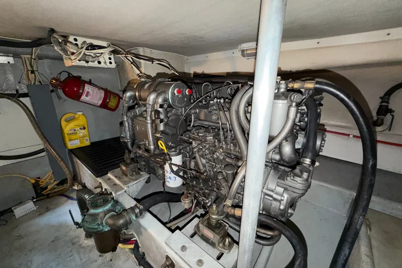 Slide: The Image of Engine room of a 2006 Mainship 34 Trawler with visible machinery and fire extinguisher. - 30