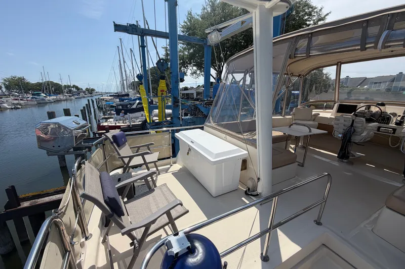 Slide: The Image of 2006 Mainship 34 Trawler docked, featuring spacious deck and seating area. - 42