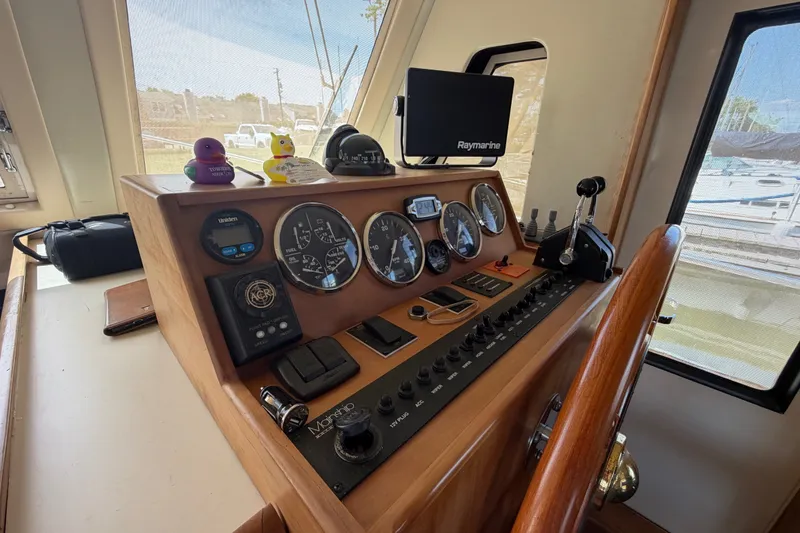 Slide: The Image of 2006 Mainship 34 Trawler helm with gauges, controls, and Raymarine navigation system. - 78