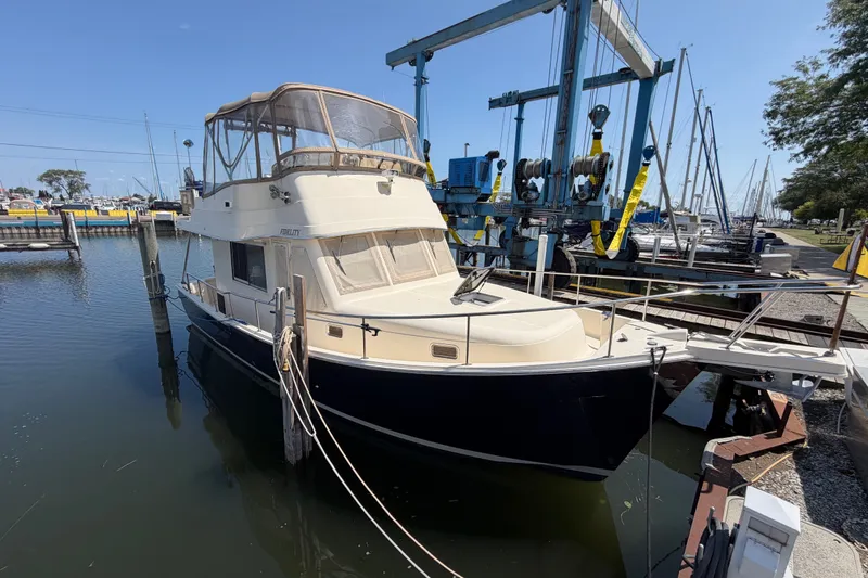 Slide: The Image of 2006 Mainship 34 Trawler docked at marina, featuring classic design and spacious cabin. - 2