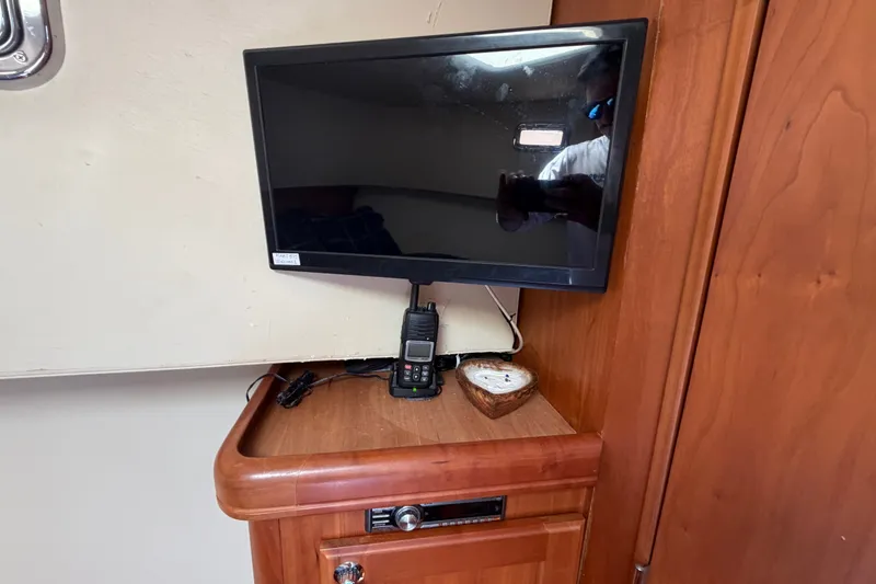 Slide: The Image of Interior of 2006 Mainship 34 Trawler with TV, radio, and wooden cabinetry. - 89