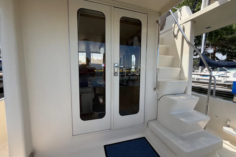 Slide: The Image of 2006 Mainship 34 Trawler with glass doors and staircase, docked at marina. - 39