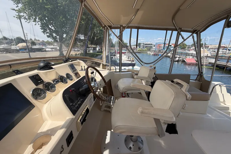 Slide: The Image of 2006 Mainship 34 Trawler helm with dual captain chairs, overlooking marina. - 49