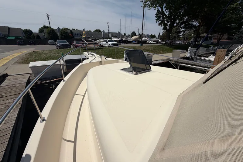 Slide: The Image of 2006 Mainship 34 Trawler docked, showcasing deck and railing in a marina setting. - 6