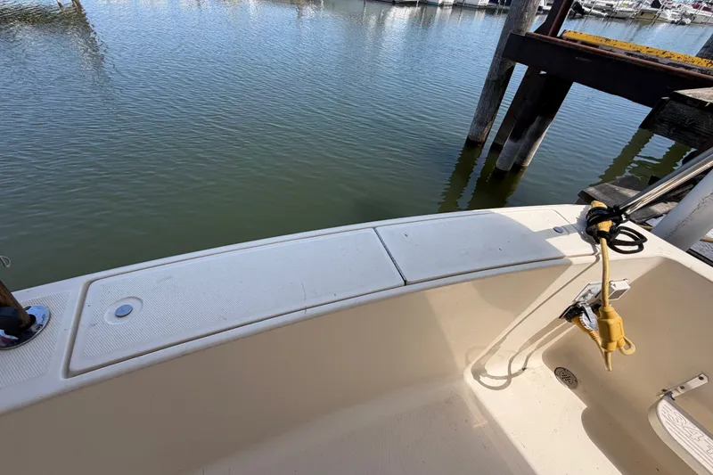 Slide: The Image of 2006 Mainship 34 Trawler deck view at marina, showcasing water and dock. - 11