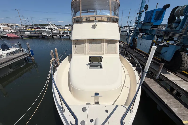 Slide: The Image of 2006 Mainship 34 Trawler docked at marina, front view with clear sky. - 4