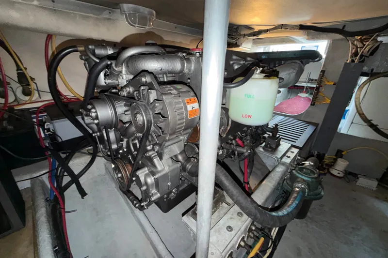 Slide: The Image of Engine room of a 2006 Mainship 34 Trawler, showcasing mechanical components and wiring. - 31