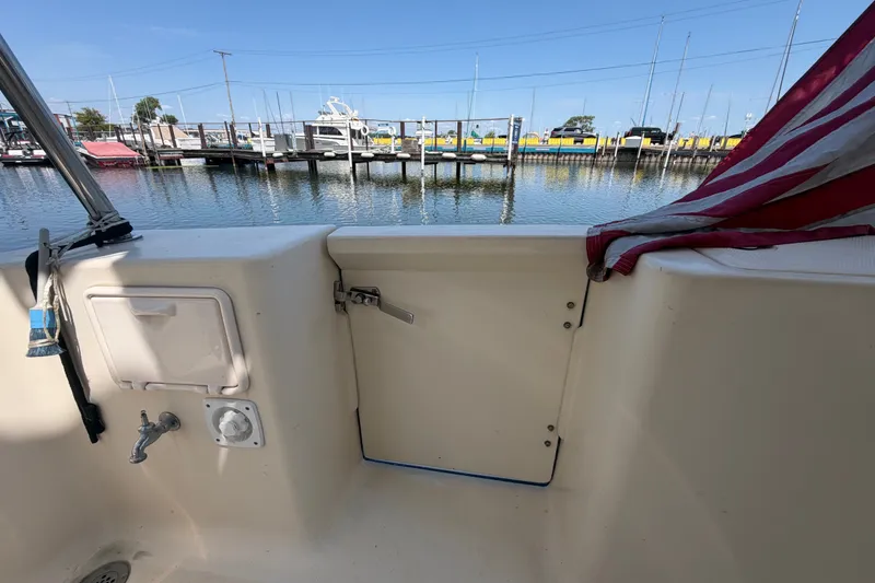 Slide: The Image of 2006 Mainship 34 Trawler deck view with marina background and American flag. - 12