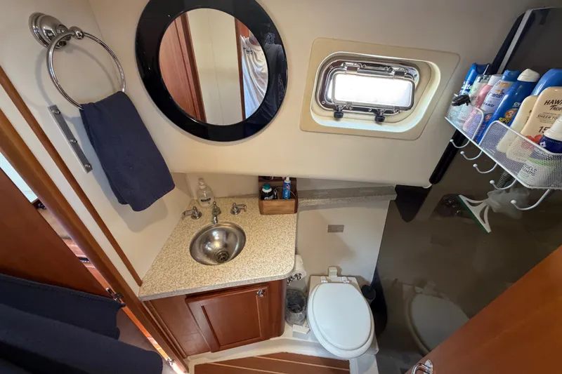 Slide: The Image of Bathroom interior of 2006 Mainship 34 Trawler with sink, mirror, and toiletries. - 94