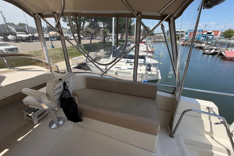 Slide: The Image of 2006 Mainship 34 Trawler interior with seating, overlooking marina with docked boats. - 48