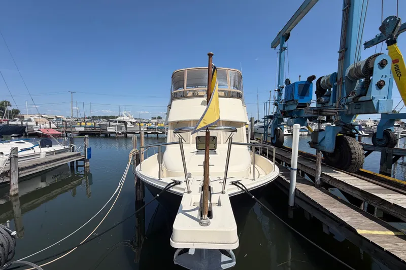 Slide: The Image of 2006 Mainship 34 Trawler docked at marina, clear sky, surrounded by boats. - 3