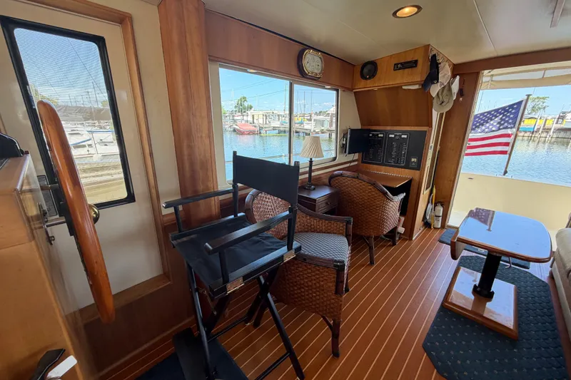 Slide: The Image of Interior of 2006 Mainship 34 Trawler with wooden flooring and marina view. - 74