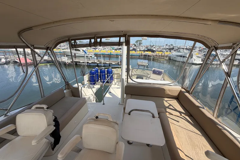 Slide: The Image of Interior view of 2006 Mainship 34 Trawler at marina, showcasing seating and docked boats. - 64