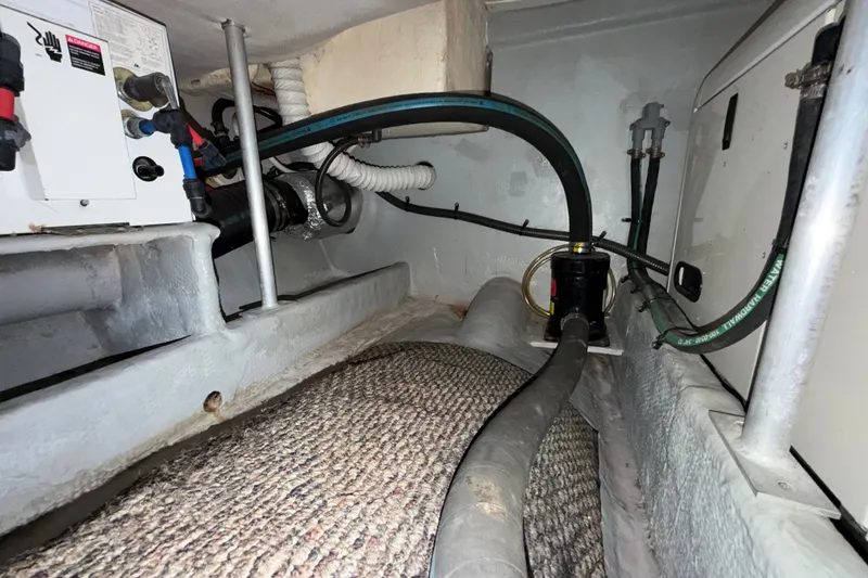 Slide: The Image of Engine compartment of a 2006 Mainship 34 Trawler, showcasing hoses and mechanical components. - 25
