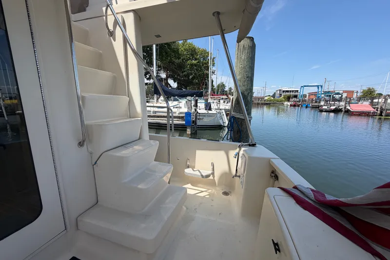 Slide: The Image of 2006 Mainship 34 Trawler docked, featuring stairs and marina view. - 16