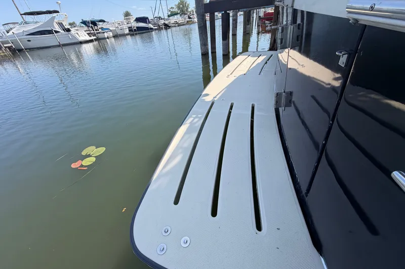 Slide: The Image of 2006 Mainship 34 Trawler docked, showcasing swim platform and marina view. - 13