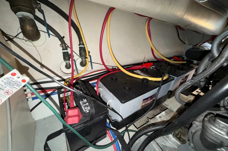 Slide: The Image of Battery compartment of a 2006 Mainship 34 Trawler with wiring and connections visible. - 33