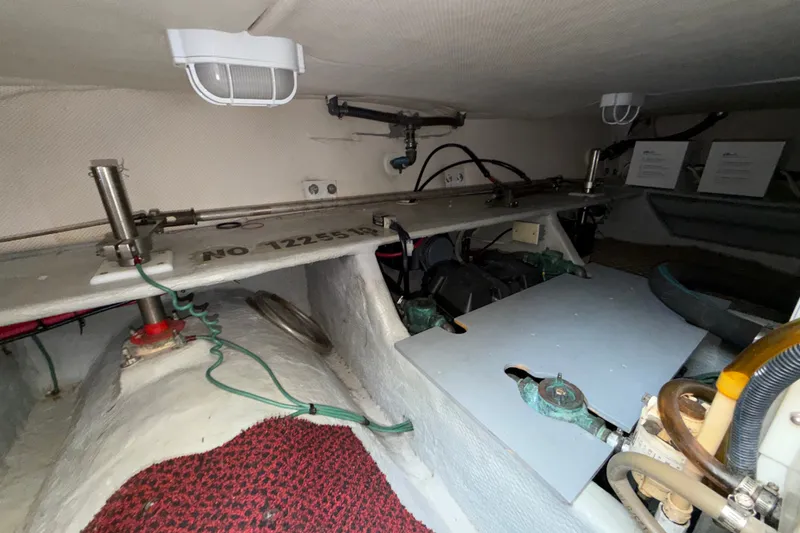 Slide: The Image of Engine compartment of a 2006 Mainship 34 Trawler, showcasing mechanical components and wiring. - 23