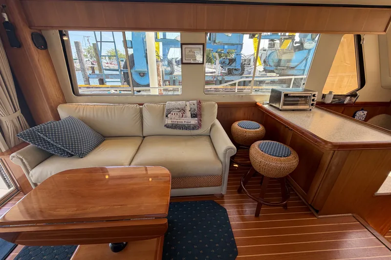 Slide: The Image of Interior of 2006 Mainship 34 Trawler with sofa, stools, and wooden accents. - 67