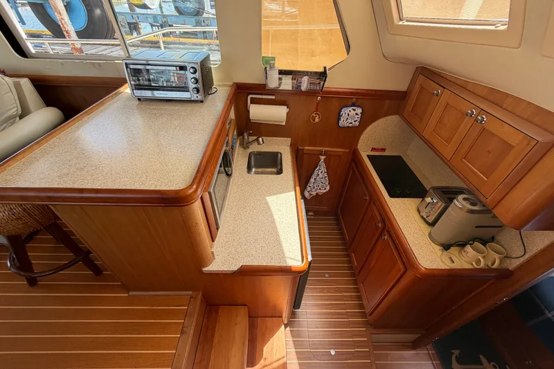 Slide: The Image of Interior of 2006 Mainship 34 Trawler kitchen with wooden cabinetry and modern appliances. - 82