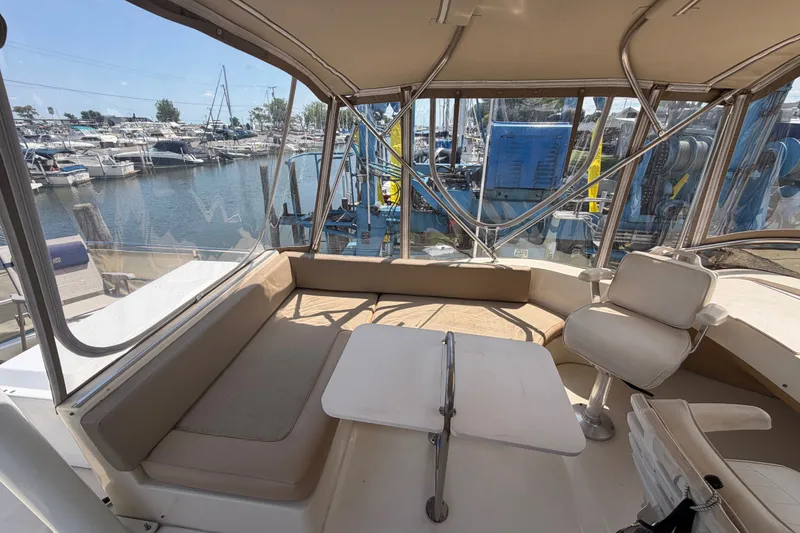 Slide: The Image of 2006 Mainship 34 Trawler interior with seating and table, docked at marina. - 47