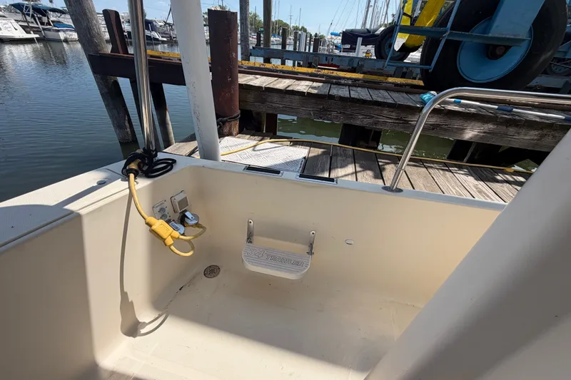 Slide: The Image of 2006 Mainship 34 Trawler docked, showing cockpit area with power connections and step. - 9
