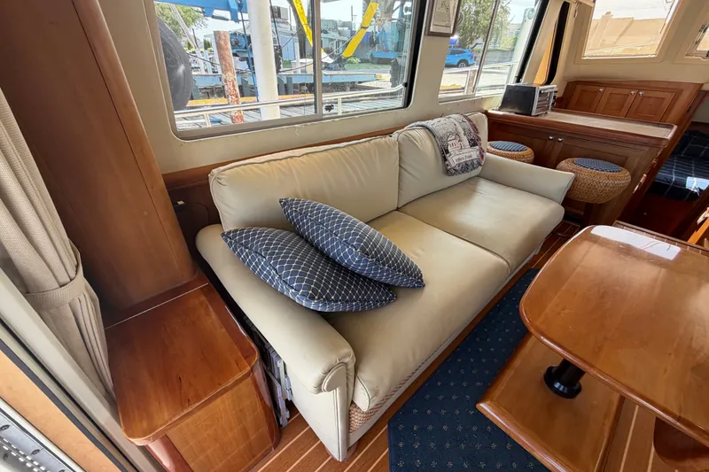 Slide: The Image of Interior of 2006 Mainship 34 Trawler with beige sofa and wooden furnishings. - 66