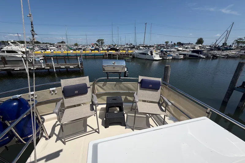 Slide: The Image of 2006 Mainship 34 Trawler deck with chairs, overlooking marina with boats. - 45