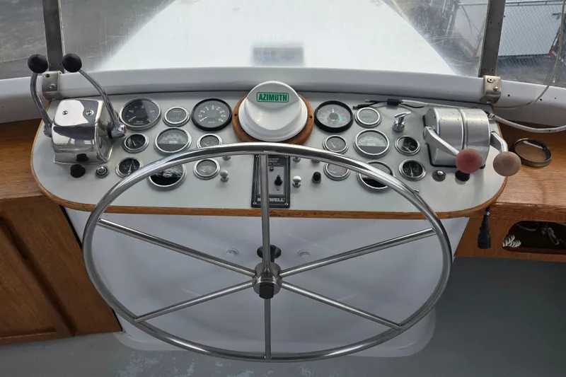 Slide: The Image of 1984 Raymond Hunt Sport Fisher helm with gauges, steering wheel, and controls. - 28