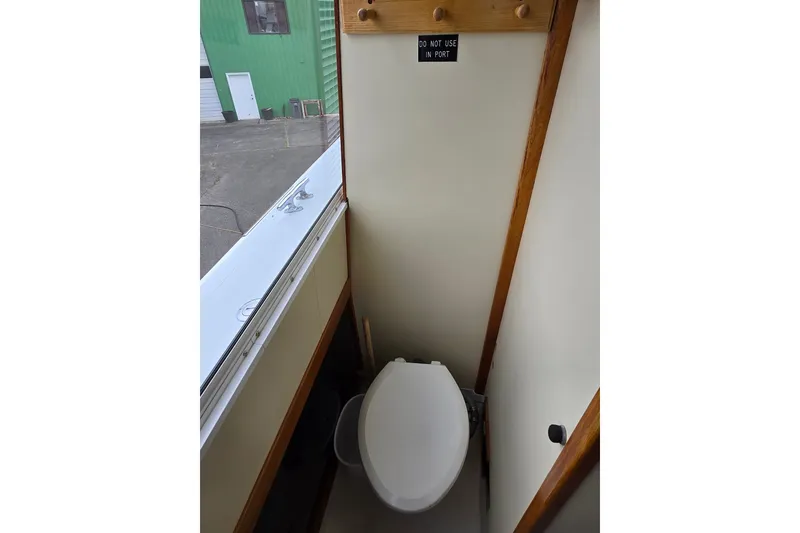 Slide: The Image of 1984 Raymond Hunt Sport Fisher boat toilet with "Do Not Use In Port" sign. - 19