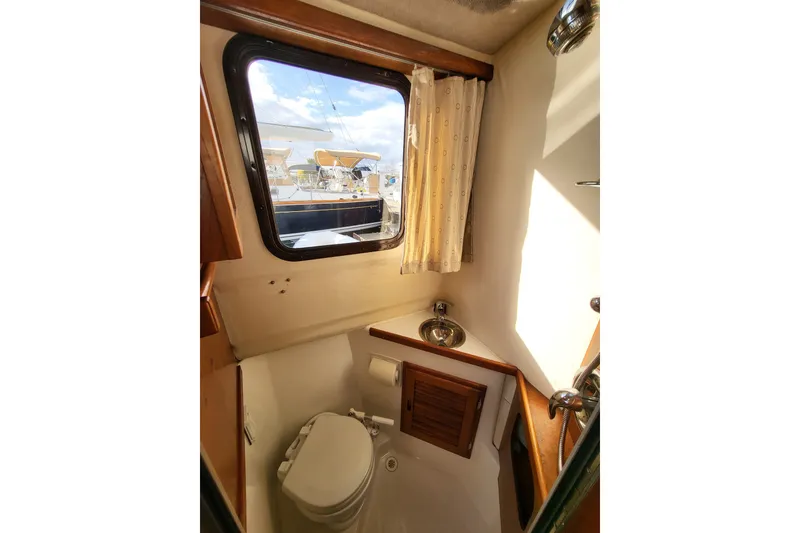 Slide: The Image of 1984 Raymond Hunt Sport Fisher boat bathroom with window, toilet, and sink. - 18