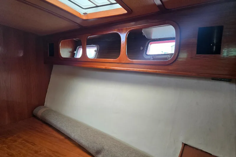 Slide: The Image of 1984 Raymond Hunt Sport Fisher cabin interior with wooden finish and porthole windows. - 13