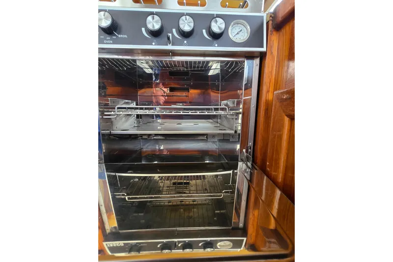 Slide: The Image of 1984 Raymond Hunt Sport Fisher boat kitchen oven with control knobs and temperature gauge. - 25
