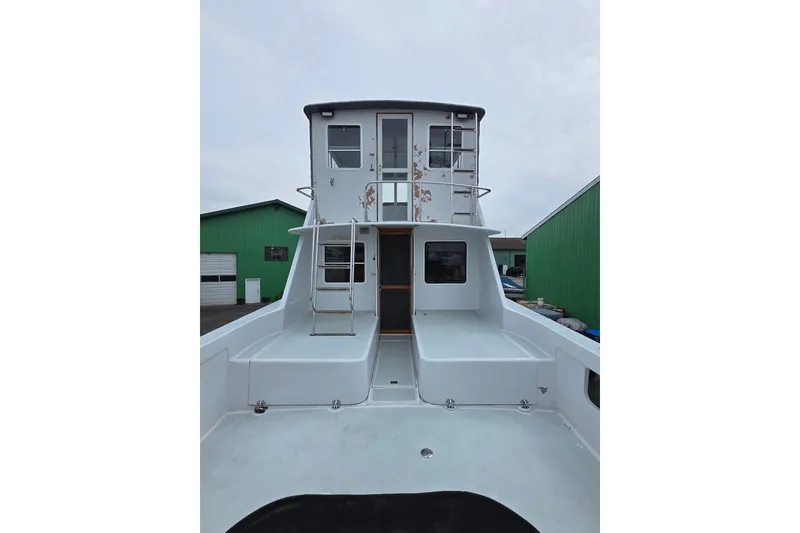 Slide: The Image of 1984 Raymond Hunt Sport Fisher boat with spacious deck and upper cabin view. - 23