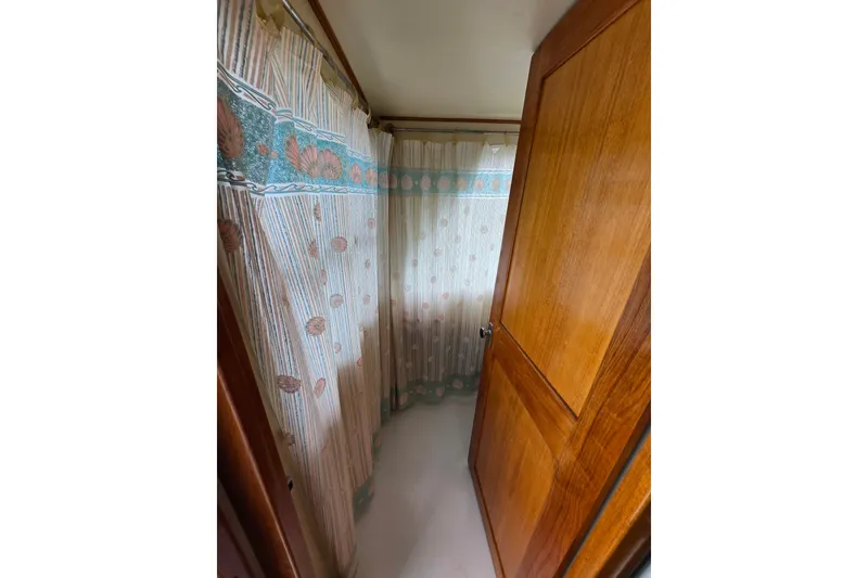Slide: The Image of Narrow bathroom with floral curtains on a 1984 Raymond Hunt Sport Fisher boat. - 31