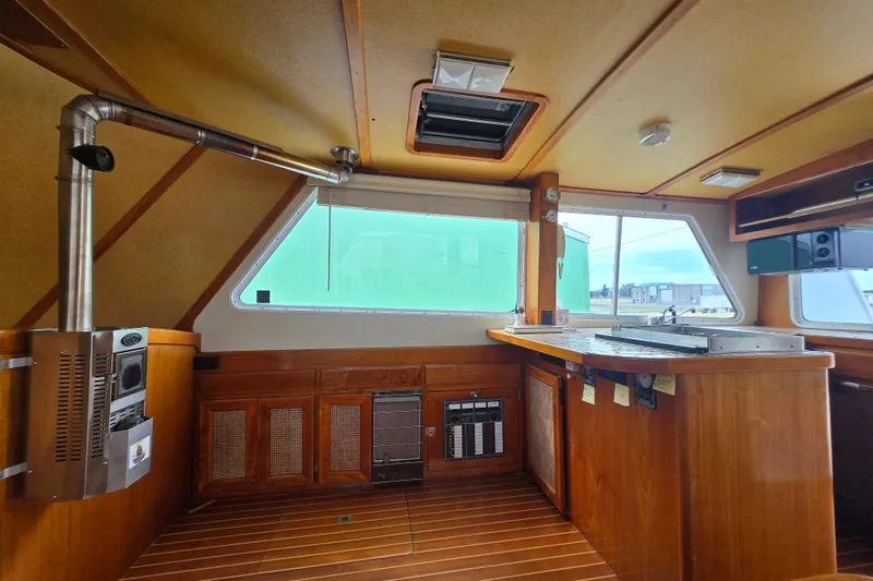 Slide: The Image of Interior of a 1984 Raymond Hunt Sport Fisher boat with wooden cabinetry and modern amenities. - 6