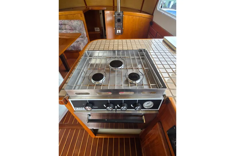 Slide: The Image of 1984 Raymond Hunt Sport Fisher interior with stove and wooden cabinetry. - 24