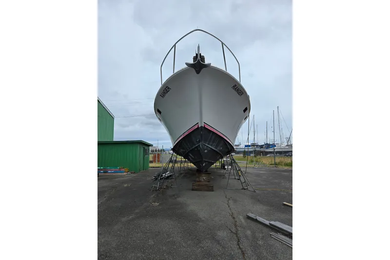 Slide: The Image of 1984 Raymond Hunt Sport Fisher boat on dry dock, with marina background. - 2