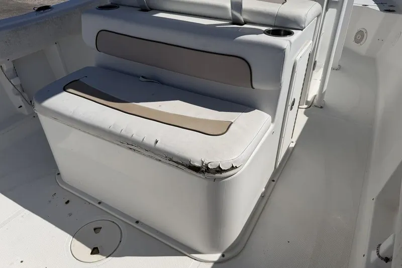 Slide: The Image of 2013 Sea Hunt Ultra 234 boat seat with visible wear and tear. - 11