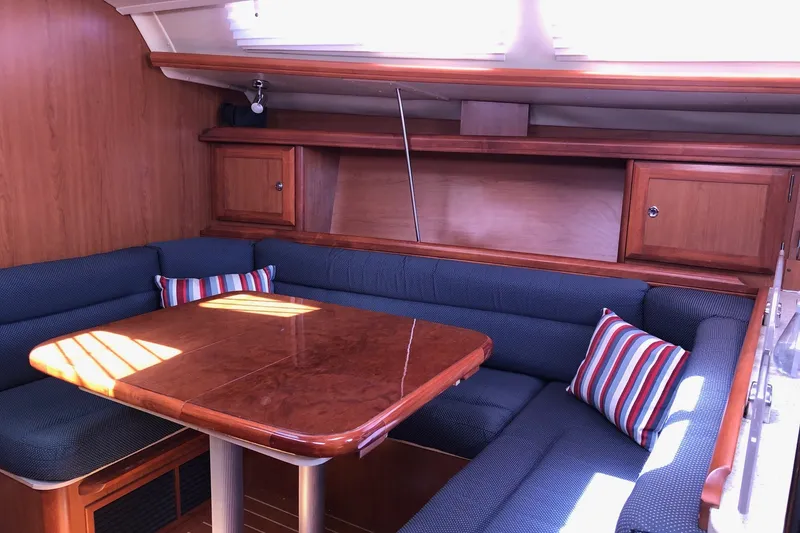 Slide: The Image of Interior of 2008 Hunter 38 sailboat with wooden table and blue seating. - 4