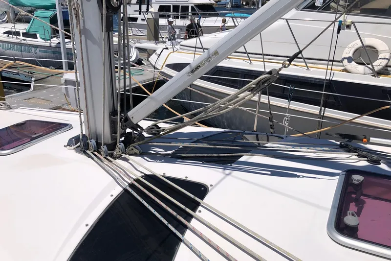 Slide: The Image of Sailboat deck of a 2008 Hunter 38, featuring rigging and hatches in a marina. - 21
