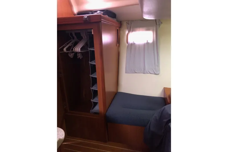 Slide: The Image of Interior cabin of 2008 Hunter 38 sailboat with wooden closet and seating area. - 12