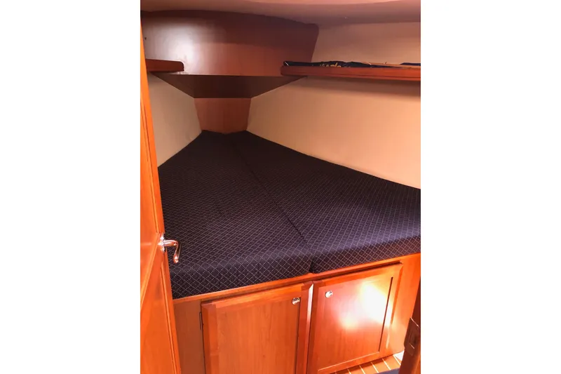 Slide: The Image of Interior cabin of a 2008 Hunter 38 sailboat with wooden cabinetry and a cozy bed. - 9