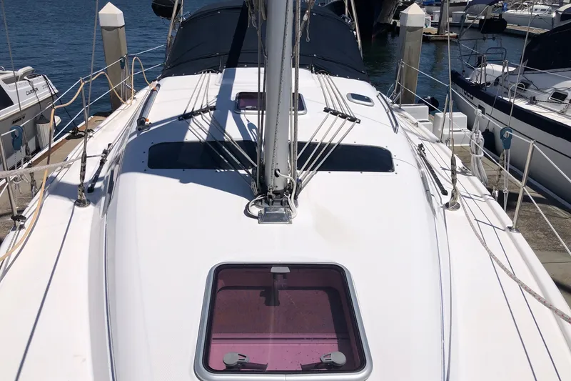 Slide: The Image of 2008 Hunter 38 sailboat deck view at marina, showcasing rigging and hatches. - 19