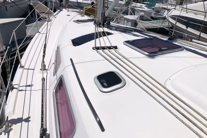Slide: The Image of 2008 Hunter 38 sailboat deck with hatches and rigging in marina setting. - 17