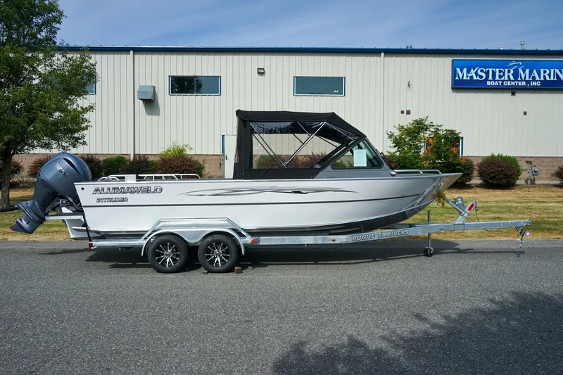 Slide: The Image of 2026 Alumaweld Intruder Outboard 22 boat on trailer, parked outside Master Marine Boat Center. - 2
