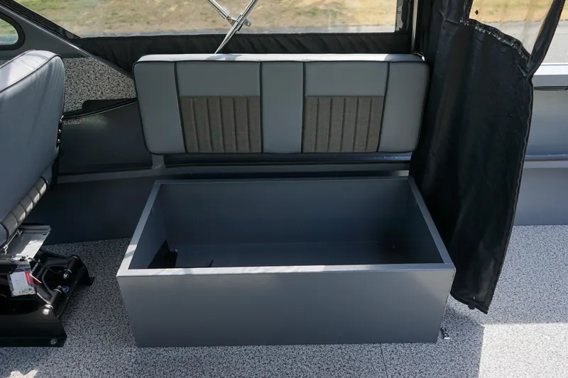 Slide: The Image of 2026 Alumaweld Intruder Outboard 22 interior storage compartment with gray seating and flooring. - 9