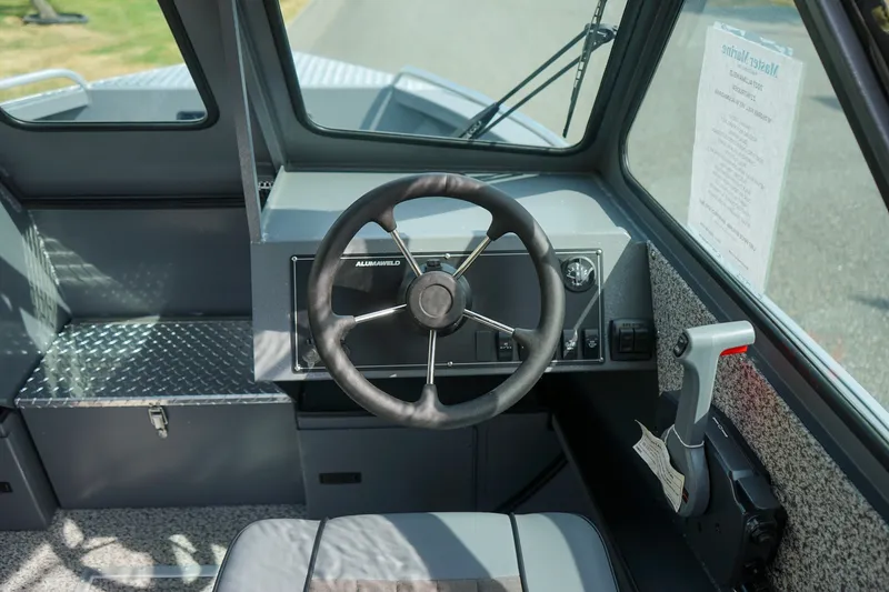 Slide: The Image of 2026 Alumaweld Intruder Outboard 22 boat cockpit with steering wheel and control panel. - 13