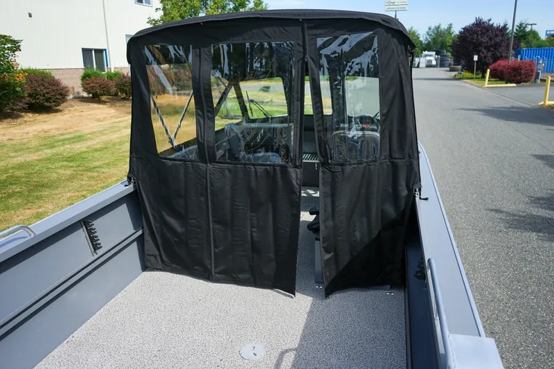 Slide: The Image of 2026 Alumaweld Intruder Outboard 22 boat with black canopy and spacious deck. - 5