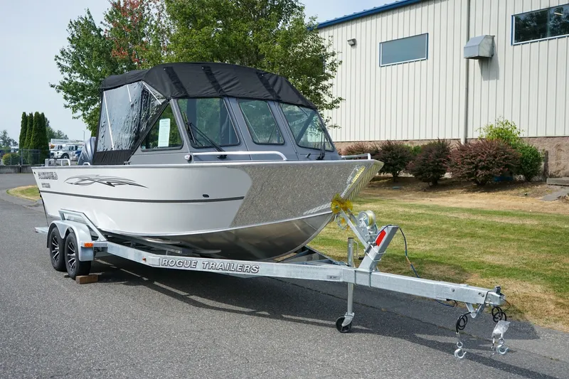 The Image of 2026 Alumaweld Intruder Outboard 22 boat on Rogue trailer, parked outdoors. - 1